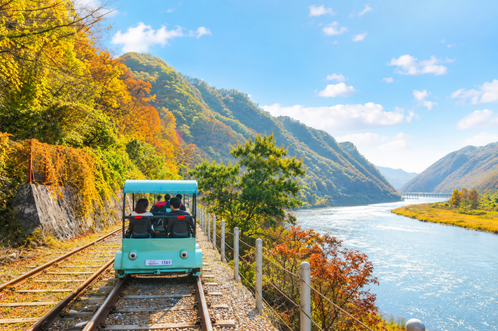 Family riding the Gangchon Rail Bike along the Bukhangang River near Gimyujeong Station in Korea