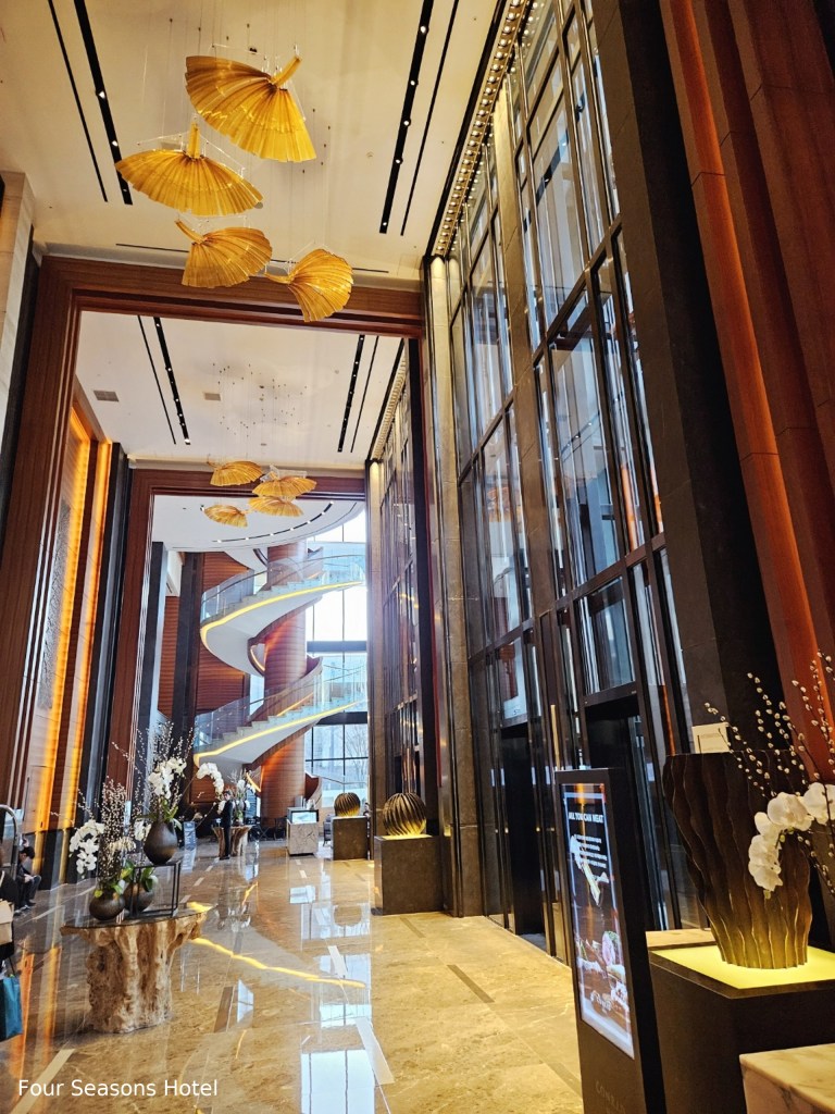 Four Seasons Hotel Seoul lobby with grand spiral staircase, golden art installation, and luxury interior design