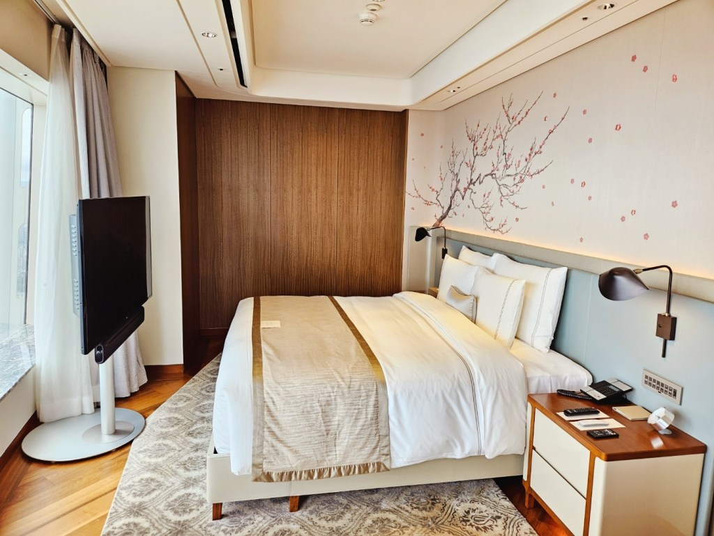 SIGNIEL Seoul hotel room with comfortable bedding, soft lighting, and wide city views.