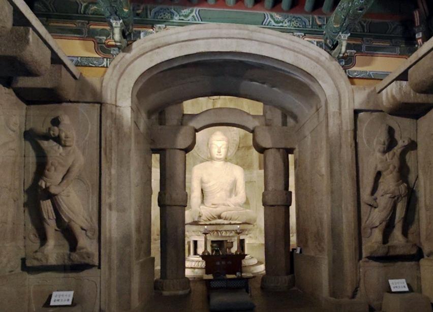 Interior view of Seokguram Grotto showing the seated Buddha statue inside the stone sanctuary, highlighting the balanced structure and calm cave atmosphere