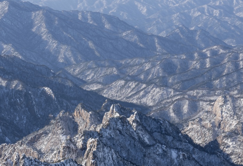 Snow-covered rocky ridges of Seoraksan National Park in winter, showing layered mountain ranges under clear winter light