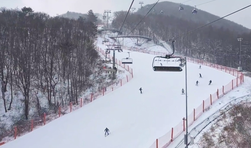 Wide ski slope at High1 Resort in winter, with chairlifts and skiers enjoying snow-covered mountains in Gangwon-do, Korea