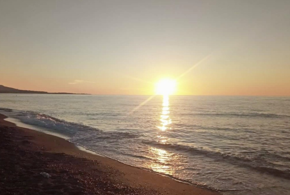 Sunrise over the calm sea on Korea’s east coast, with golden light reflecting across the shoreline