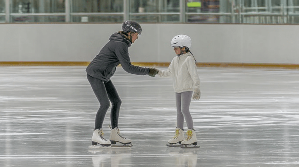 Korean female figure skating coach in her 20s teaching a 10-year-old girl during a beginner lesson on an indoor ice rink