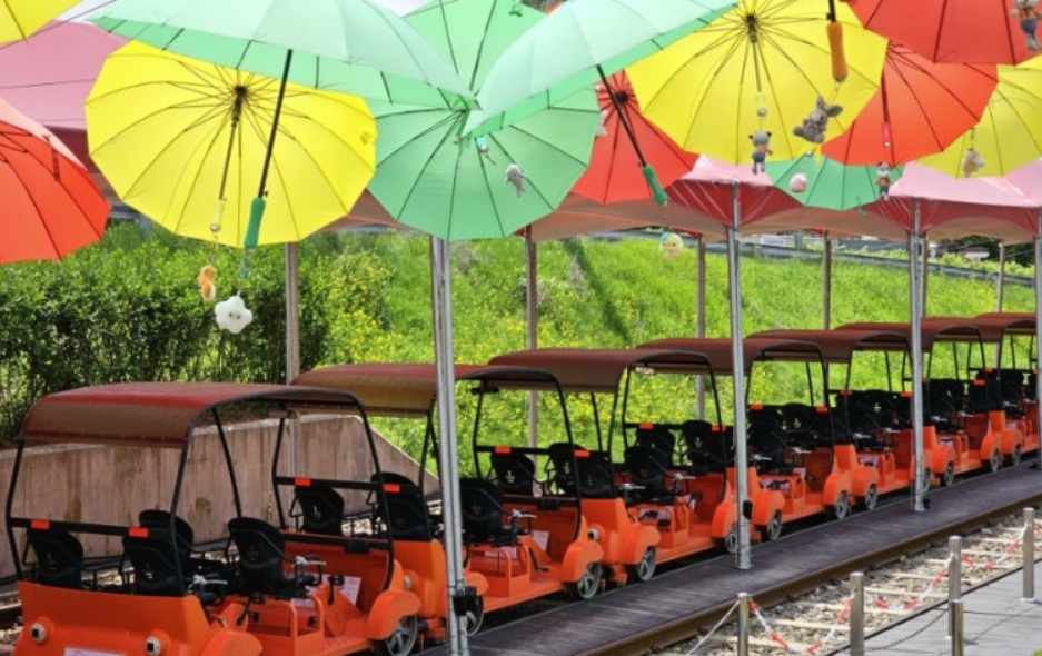 Gangchon Rail Bike in Korea with colorful umbrellas and scenic countryside track
