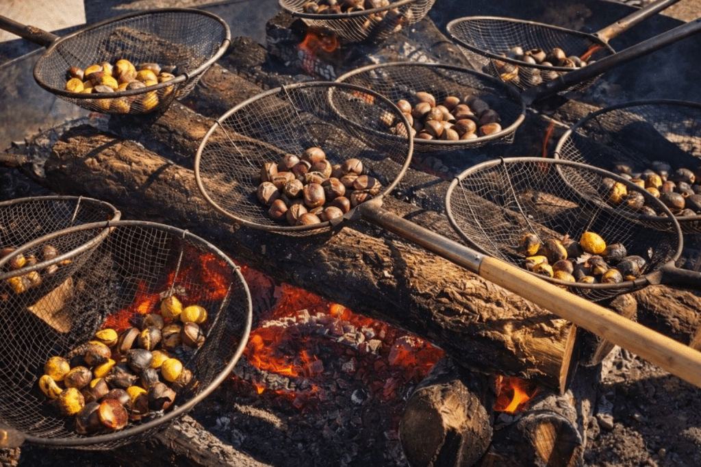 Roasting chestnuts in large wire baskets over a giant charcoal fire pit at the Gongju Chestnut Festival in South Korea