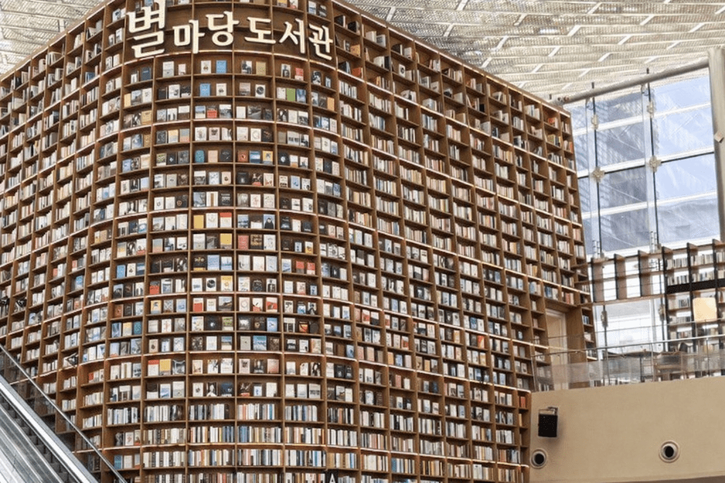 Starfield Library at COEX Mall in Gangnam, featuring a towering curved bookshelf wall filled with books inside a large indoor space, ideal for a rainy day visit in Seoul.
