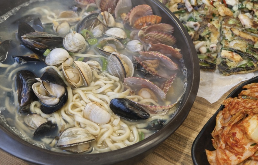 Seafood kalguksu and haemul pajeon on table in Suwon Haenggung-dong Korean restaurant